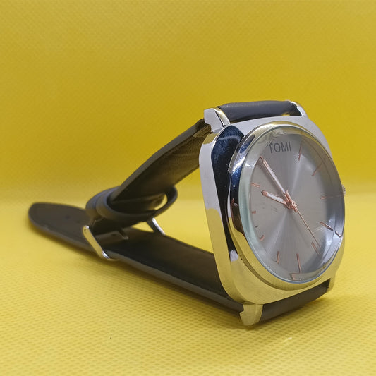 Wristwatch with black strap and silver case on a yellow background
