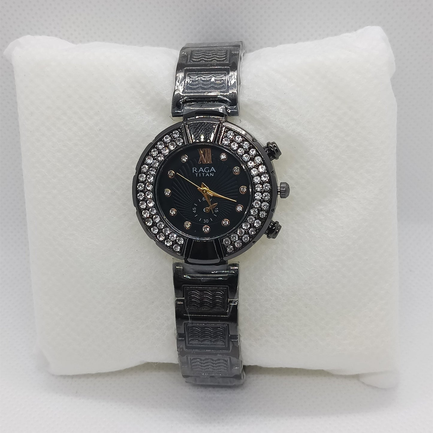 Black watch with a black face on a white cushion