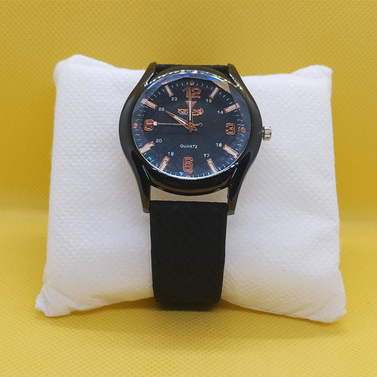 Black wristwatch with blue face on a white cushion against a yellow background