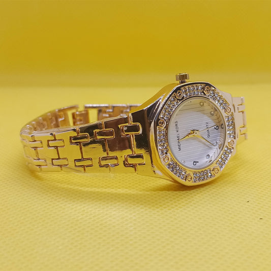 Gold wristwatch with diamond accents on a yellow background