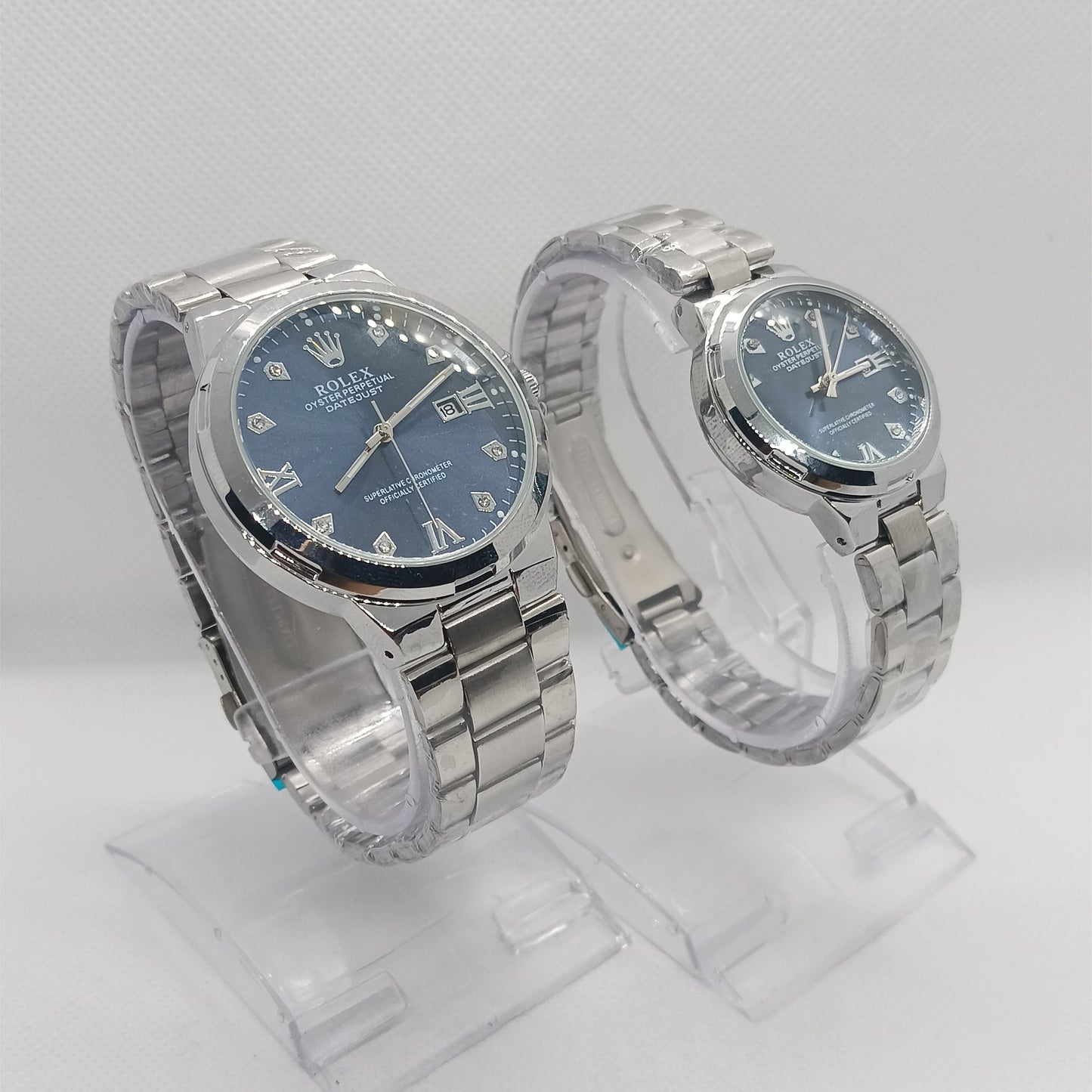 Two silver wristwatches with blue faces on a light gray background