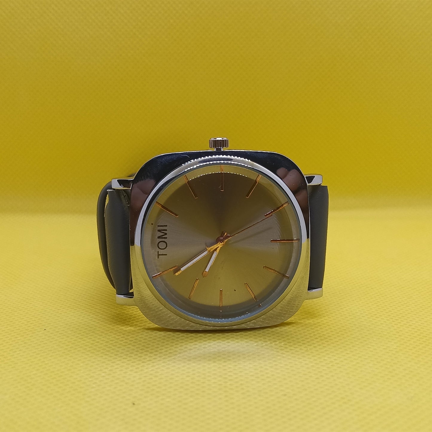 Watch with a black strap and silver case on a yellow background