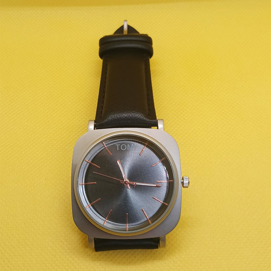 Wristwatch with black strap and silver case on a yellow background