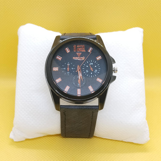 Black wristwatch with a blue dial on a white cushion against a yellow background