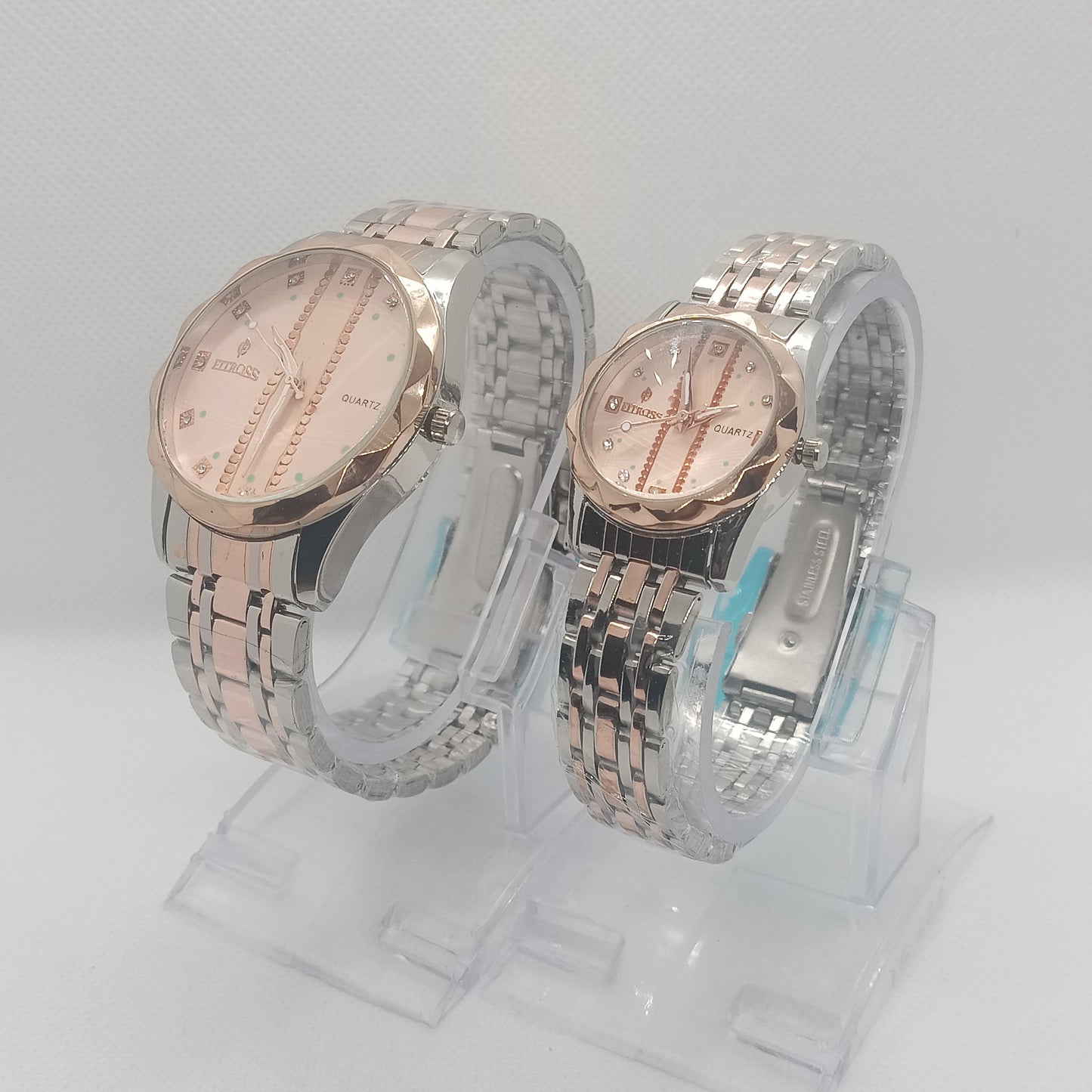 Two silver watches with pink faces on a white background