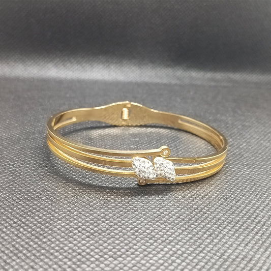 Gold bracelet with a clasp on a gray background