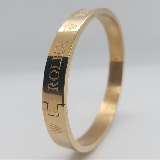 Gold bracelet with Rolex engraving on a light gray background