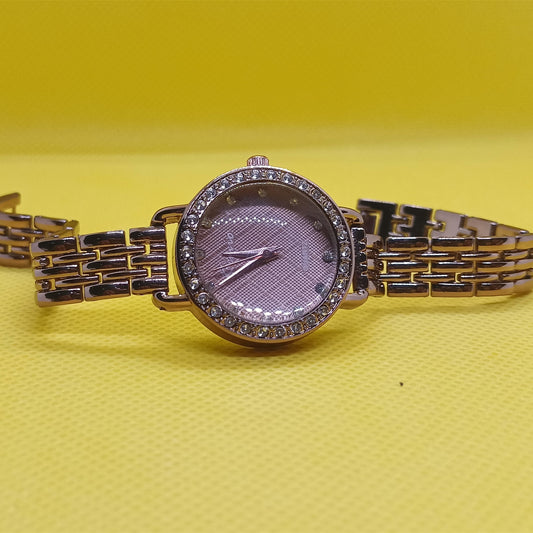 Gold watch with a purple face on a yellow background