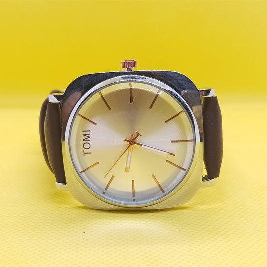 Watch with a brown strap and beige face on a yellow background