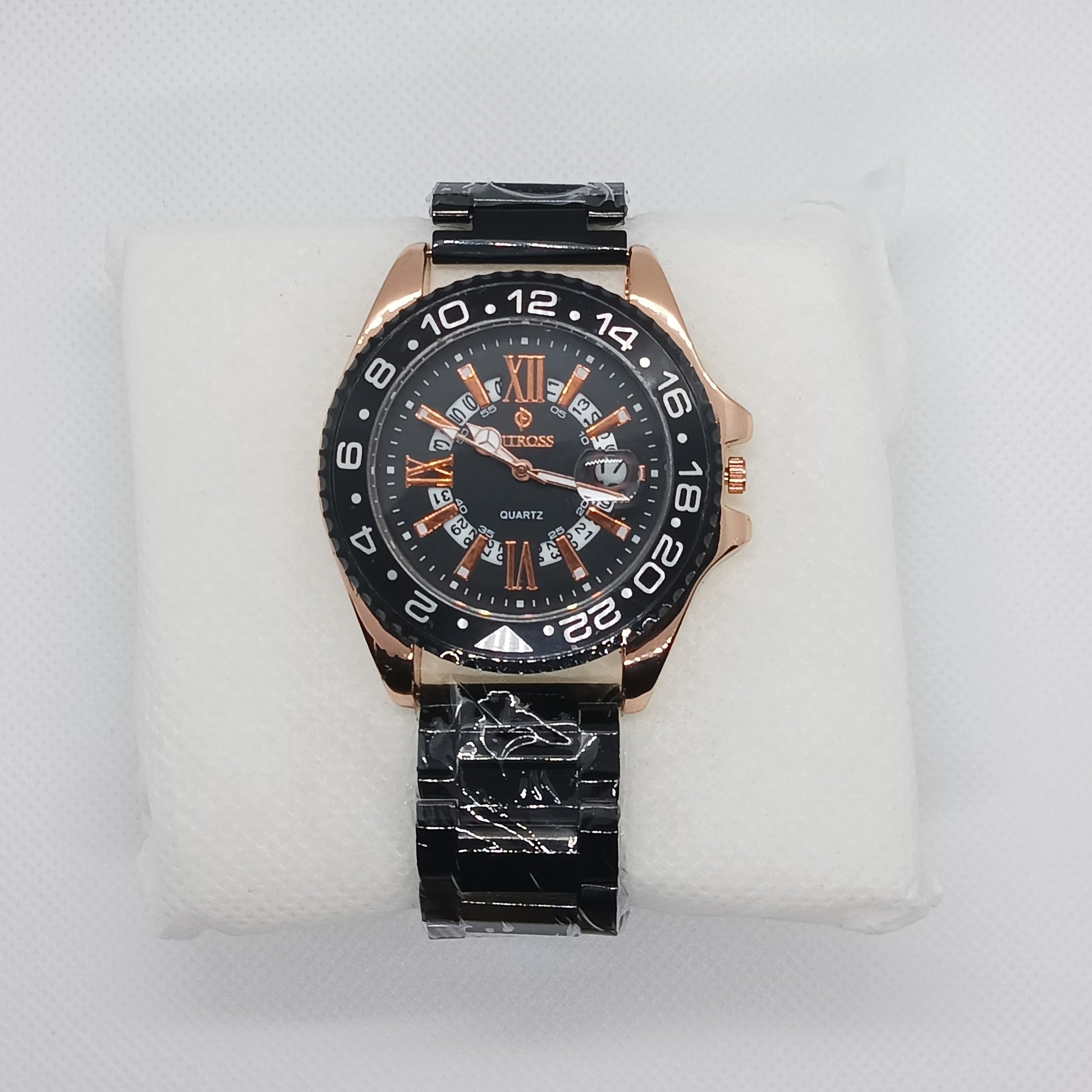 Wristwatch with black and rose gold design on a white cushion