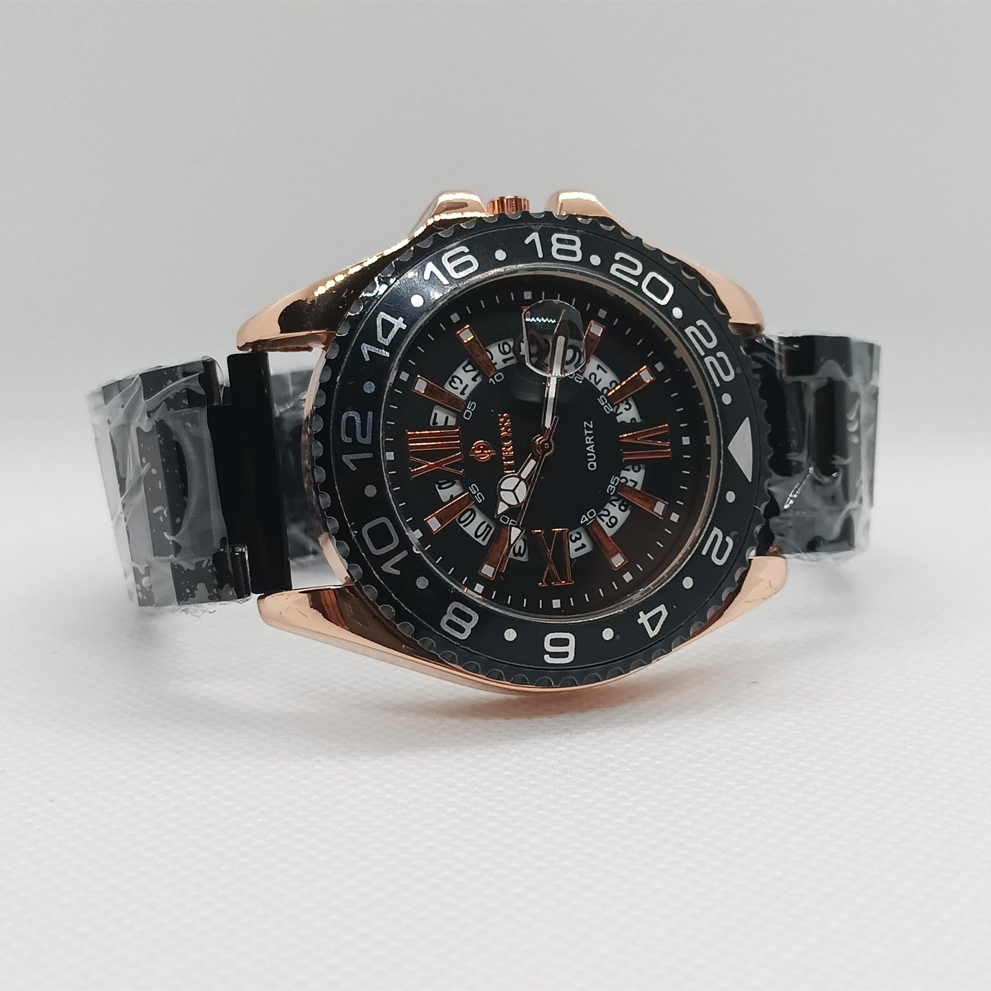 Luxury watch with black dial and rose gold case on a light gray background