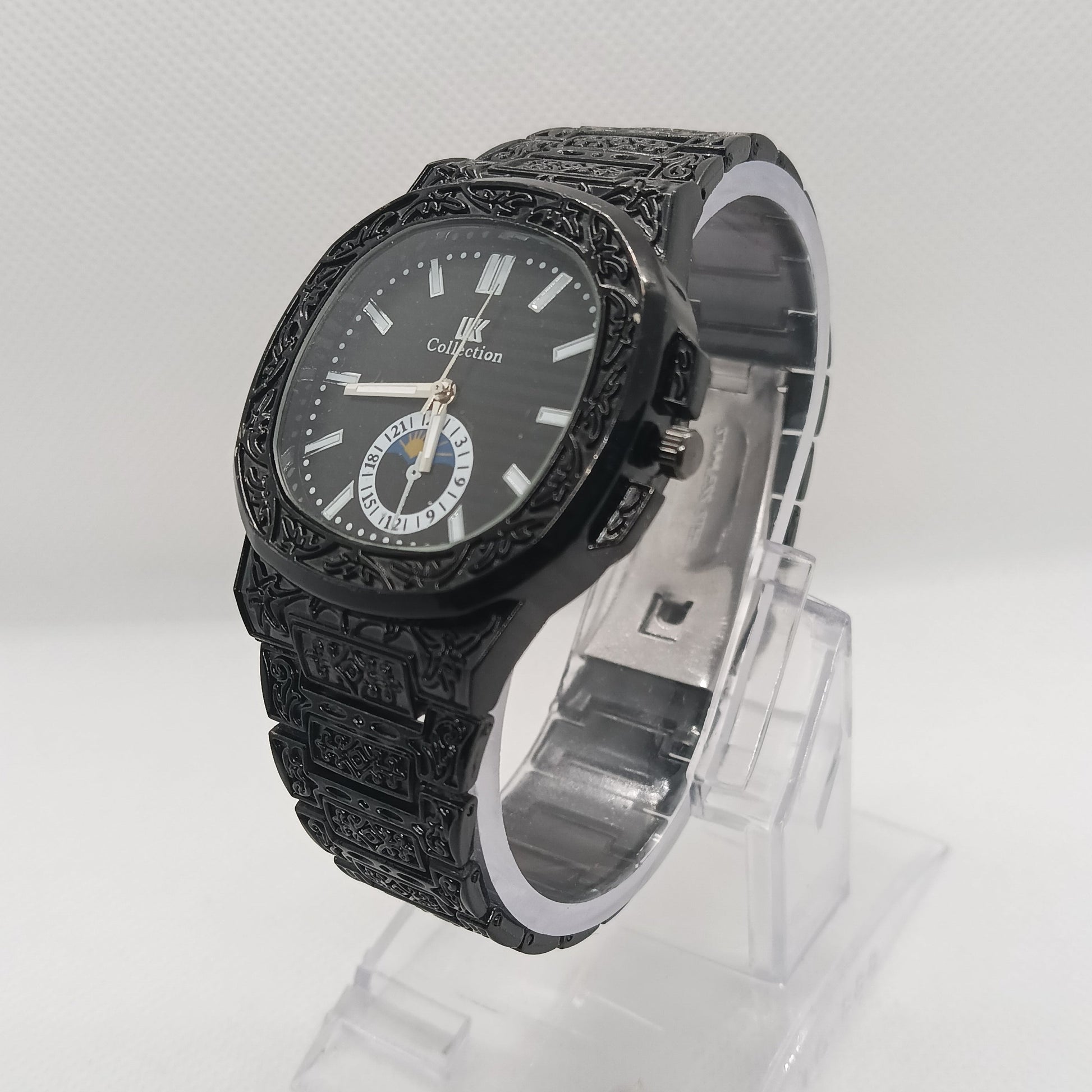 Black textured watch with clear plastic packaging on a white background