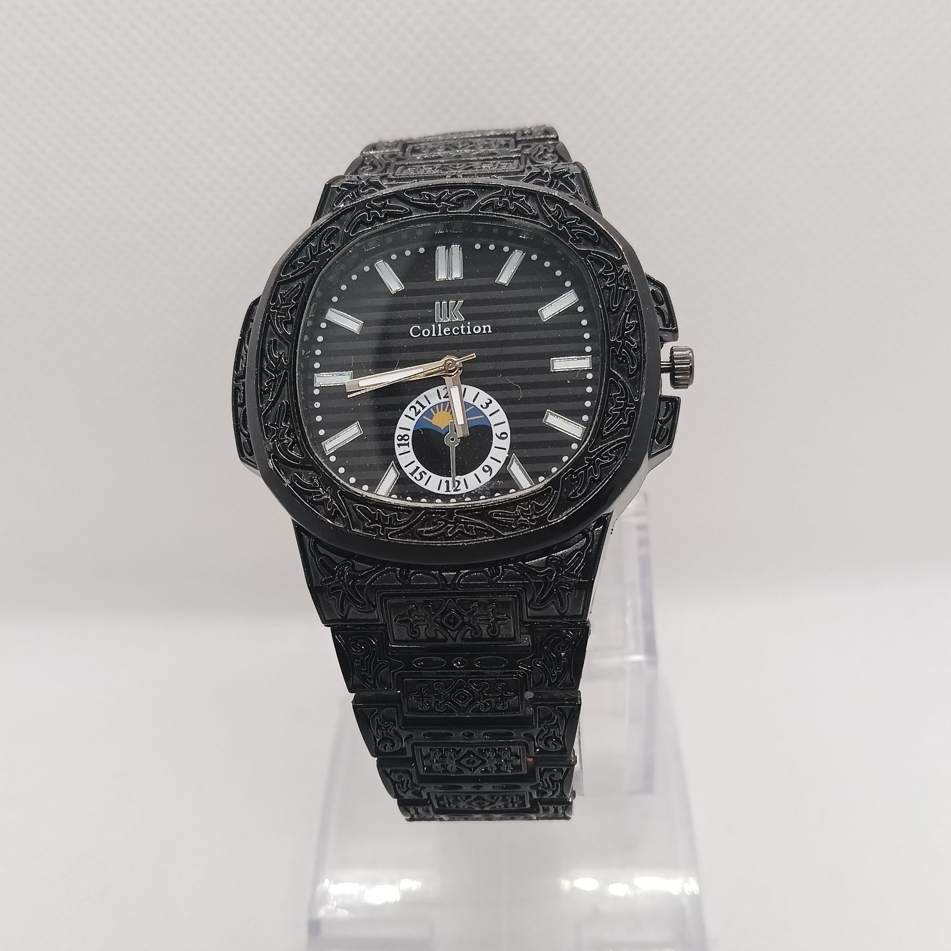 Black wristwatch with detailed design on a white background