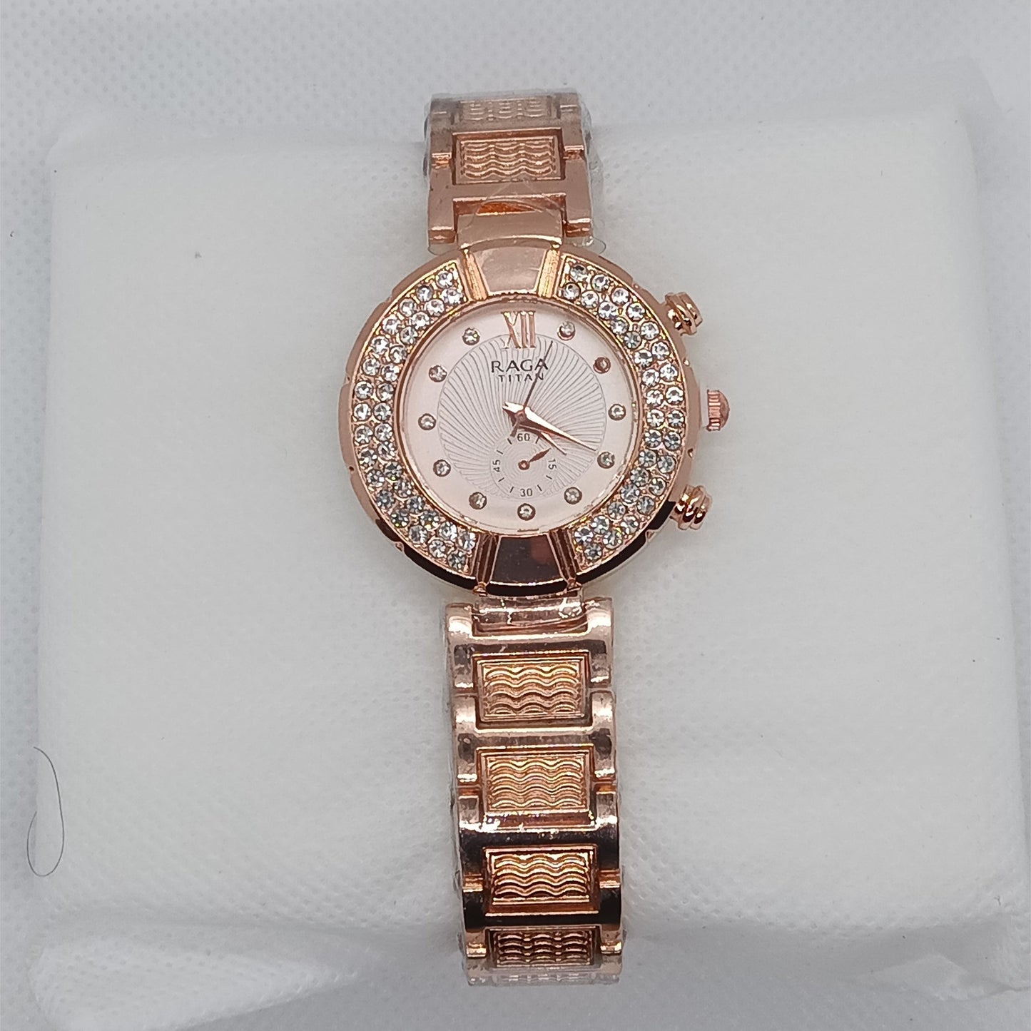 Rose gold watch with diamond-studded face on a light gray background