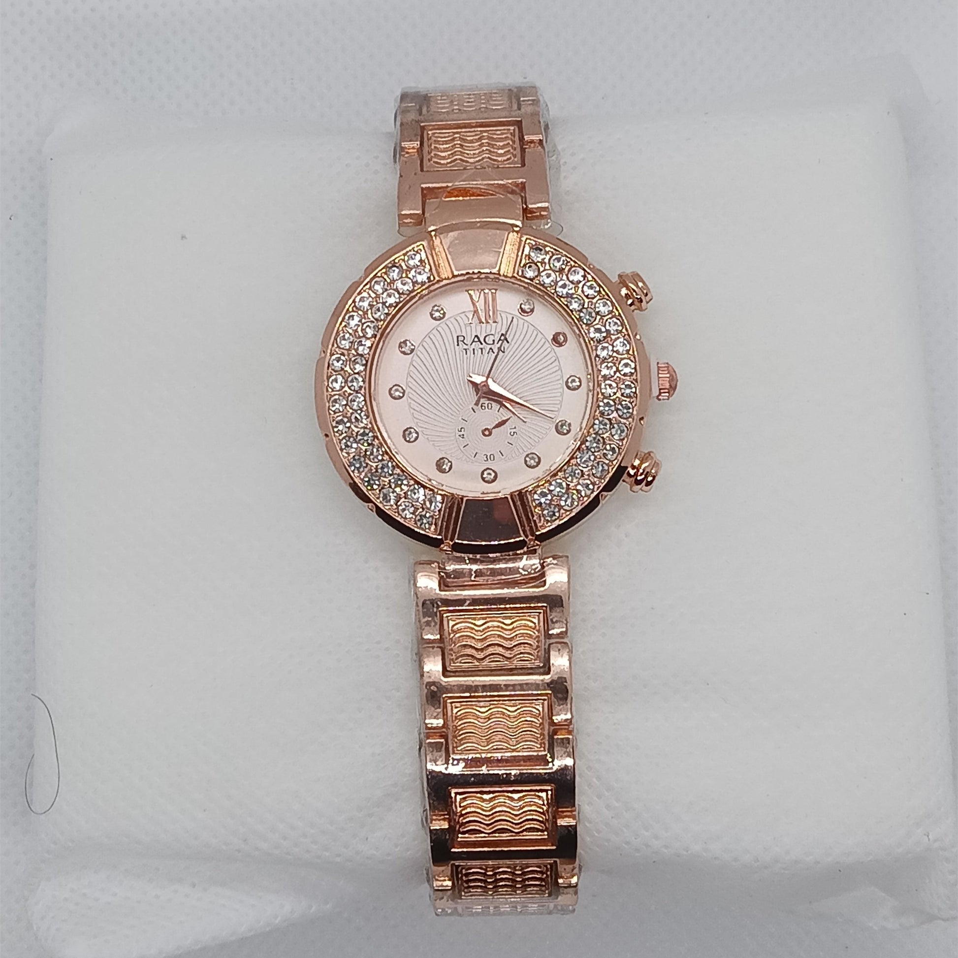 Rose gold watch with diamond-studded face on a light gray background