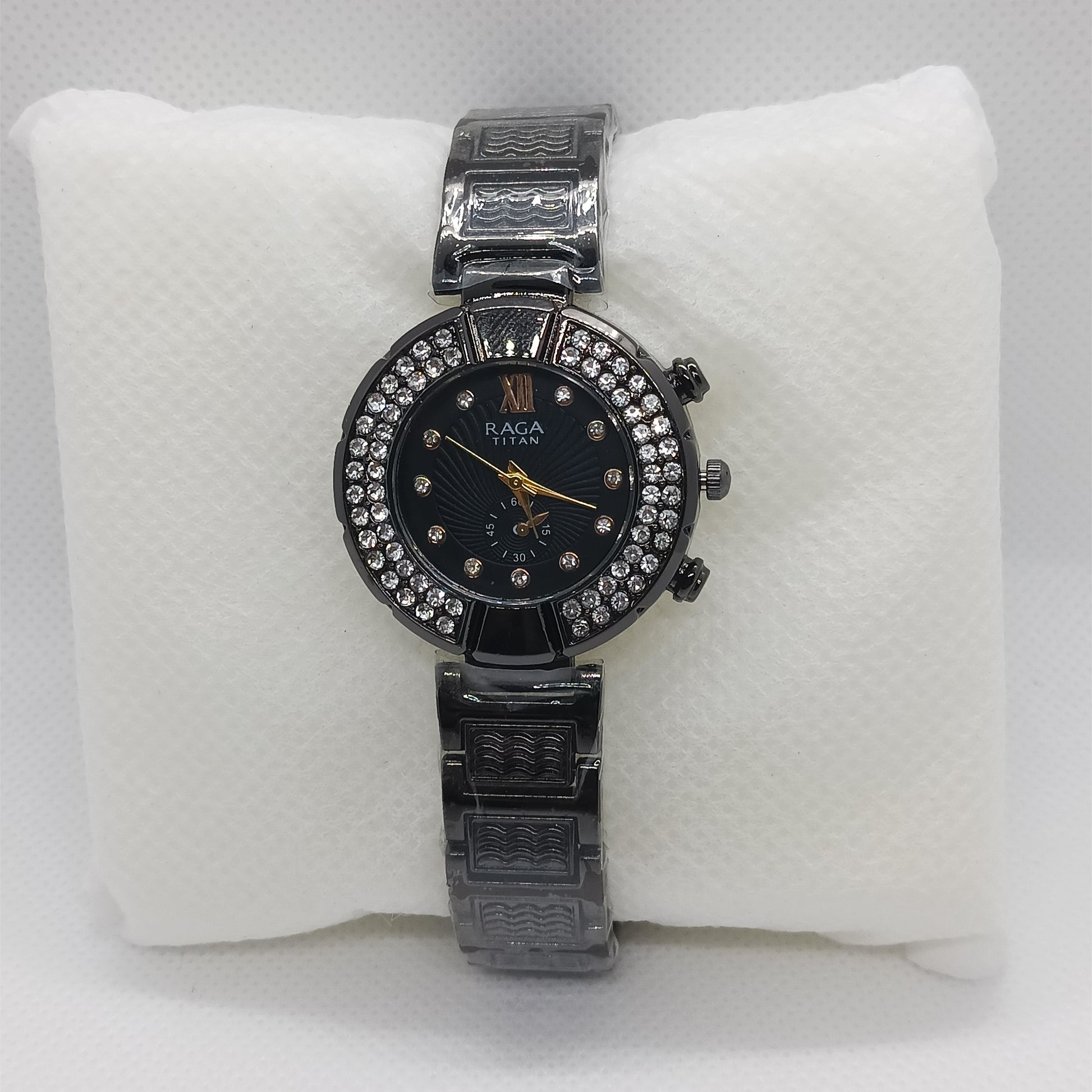 Black watch with a black face on a white cushion
