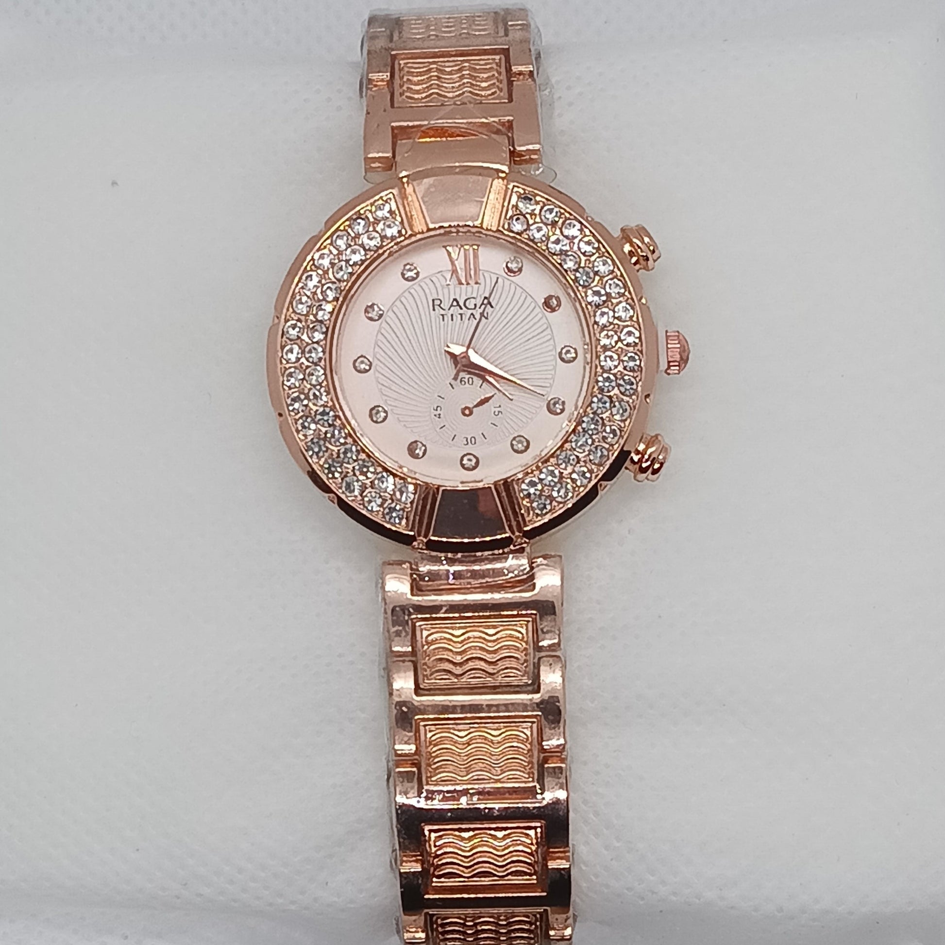 Rose gold watch with diamond-studded face on a light gray background