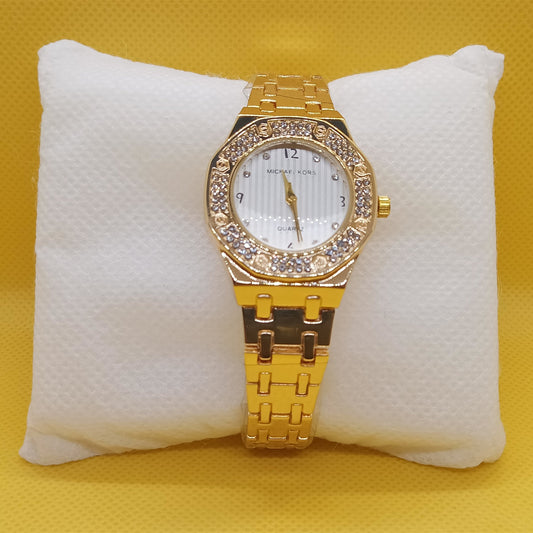 Gold wristwatch with diamond accents on a white cushion against a yellow background
