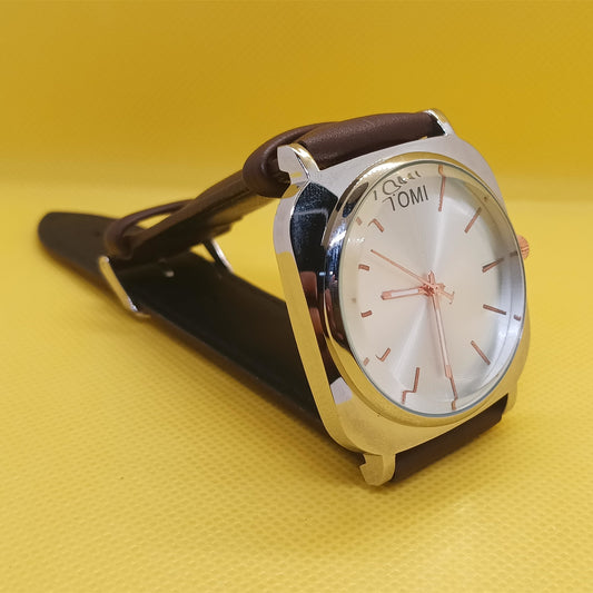 Watch with a brown strap and silver case on a yellow background
