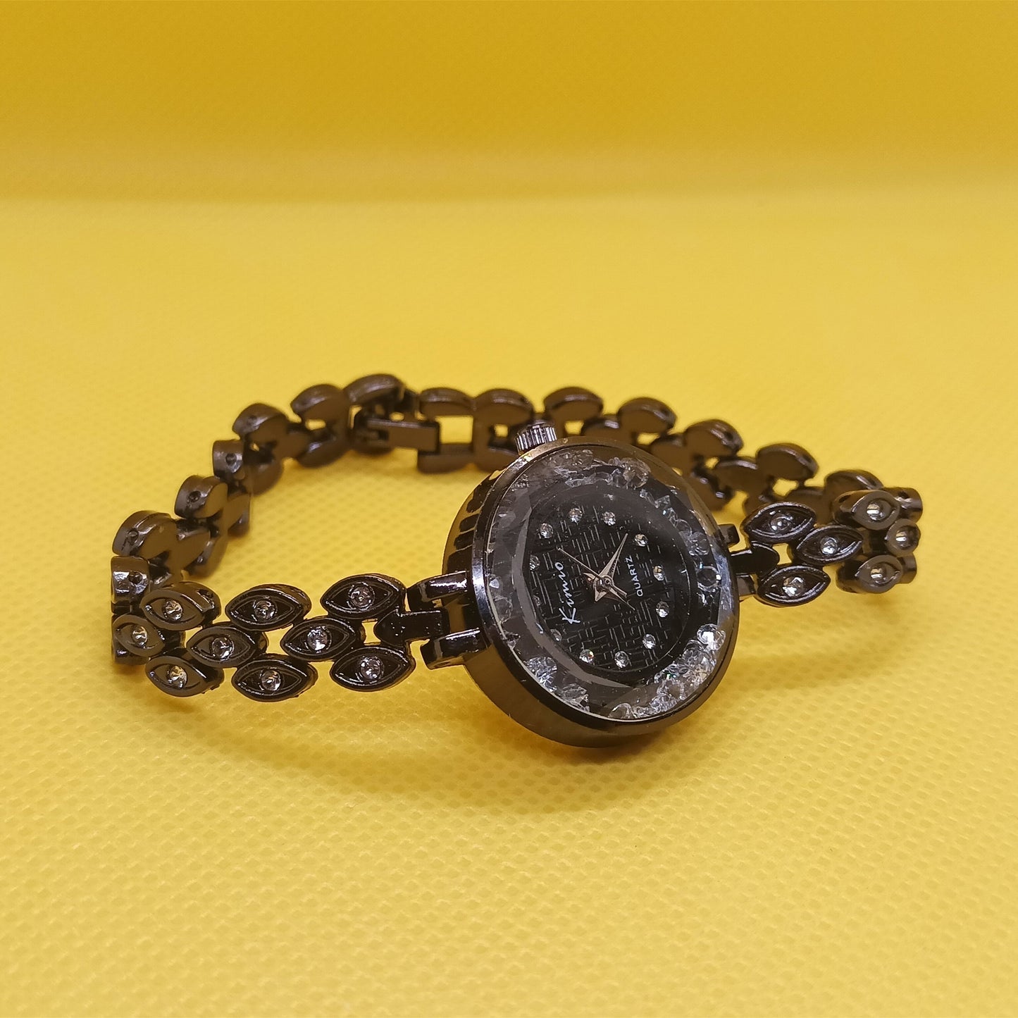 Black beaded bracelet with a round clasp on a yellow background