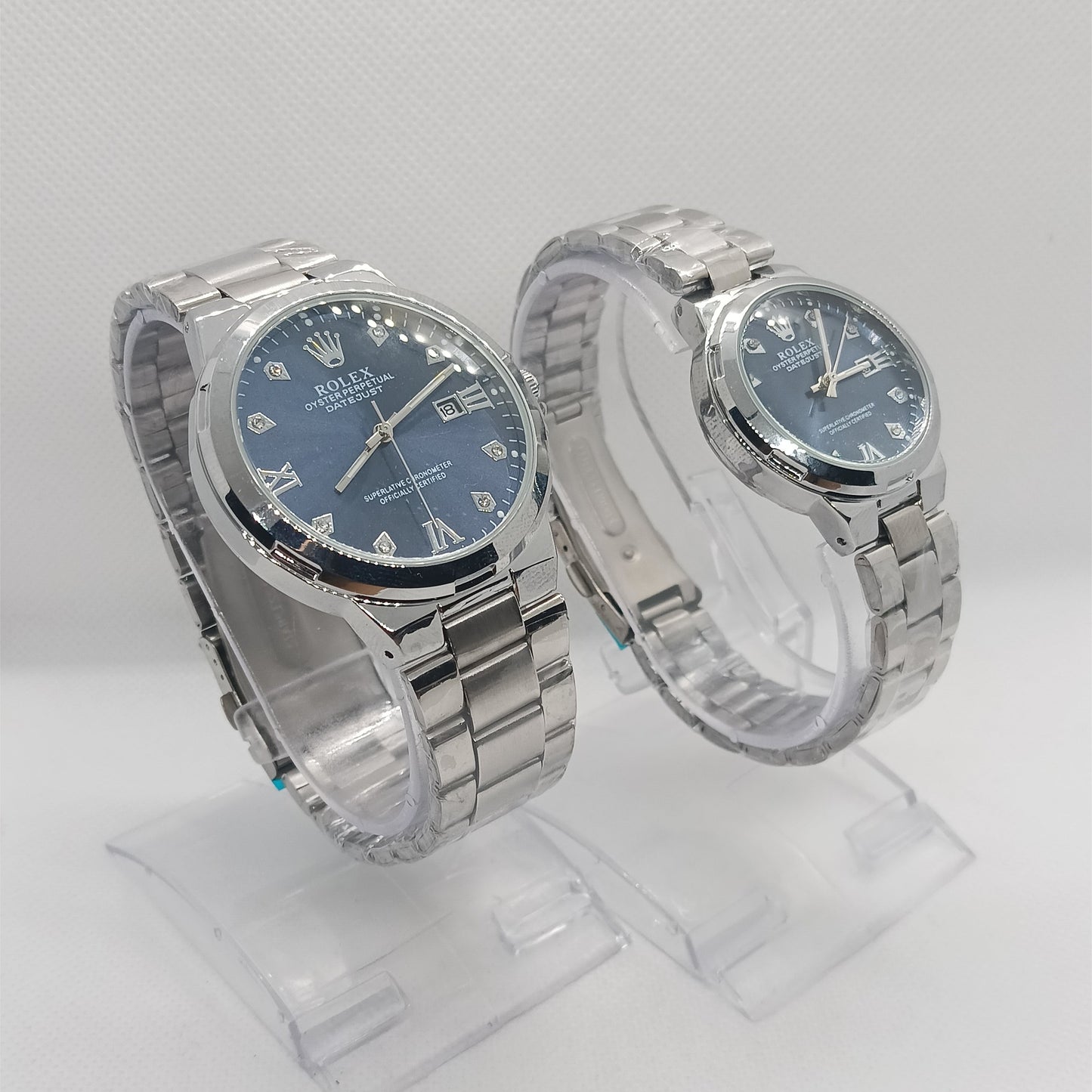 Two silver watches with blue faces on a white background