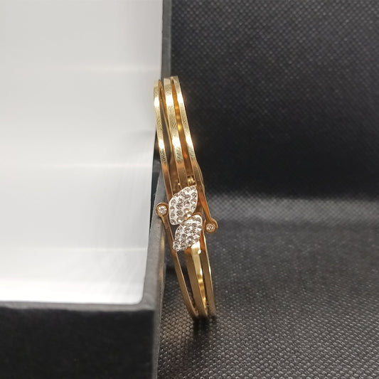 Gold bracelet with diamond accents on a textured black surface