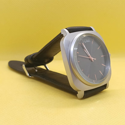 Wristwatch with black strap and silver case on a yellow background
