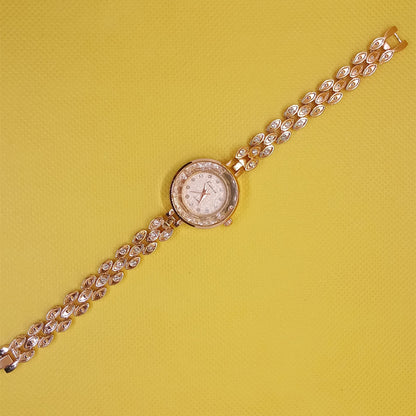 Gold wristwatch with a chain strap on a yellow background