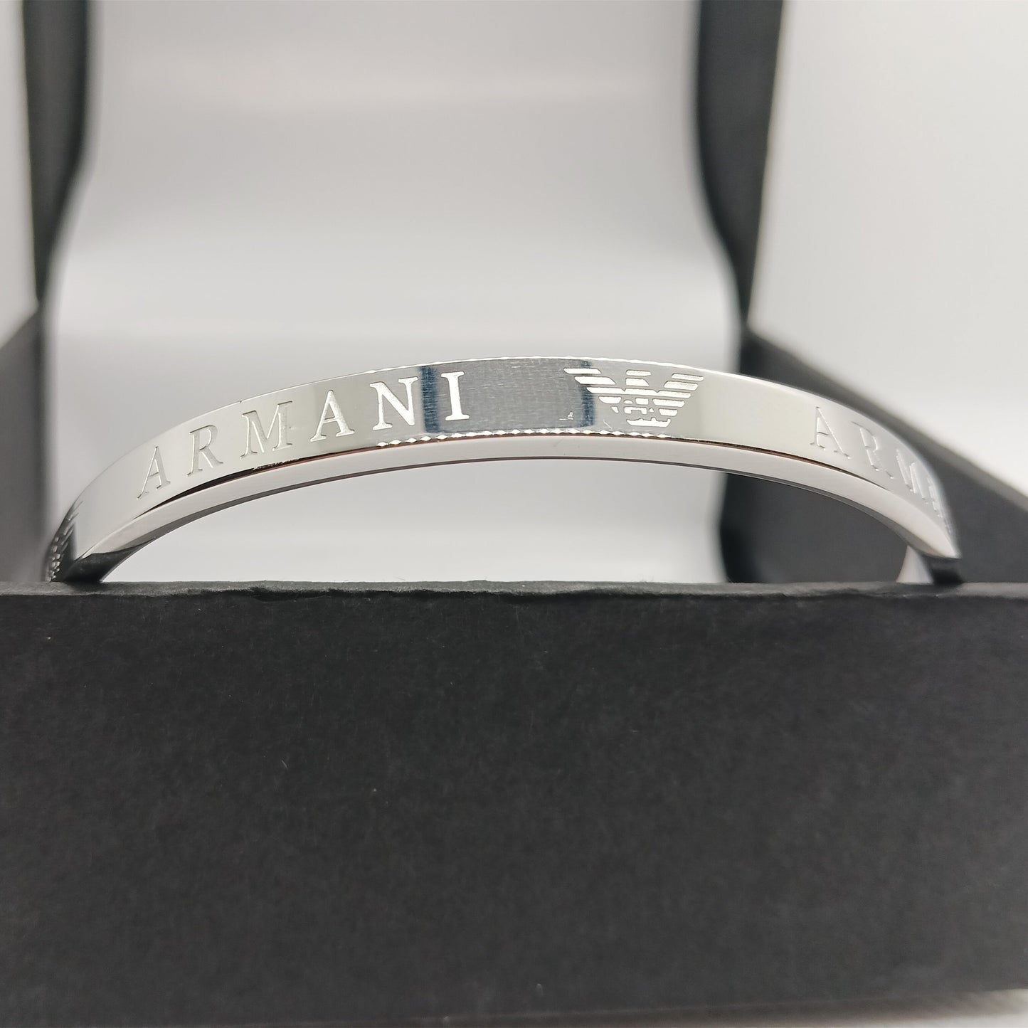 Silver Armani bracelet on a black box