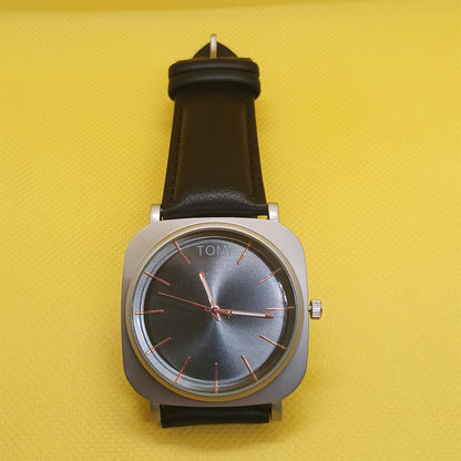 Wristwatch with black strap and silver case on a yellow background