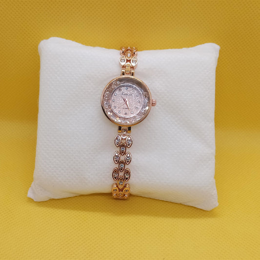 Rose gold watch on a white cushion against a yellow background