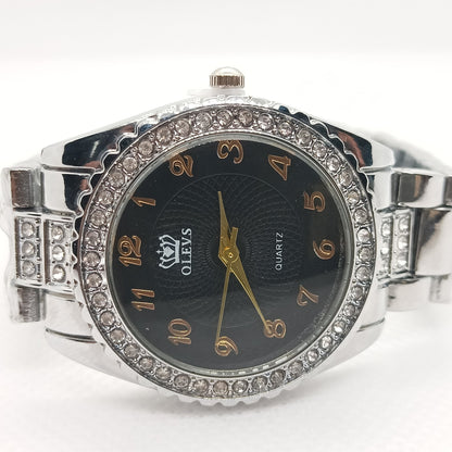 Silver watch with black face and diamond-like accents on a white background