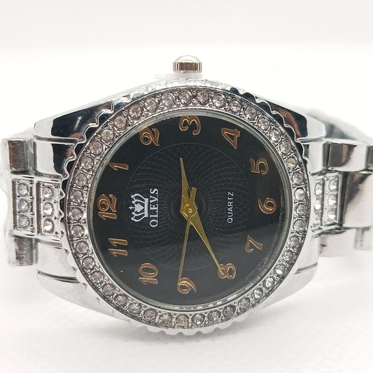 Silver watch with black face and diamond-like accents on a white background