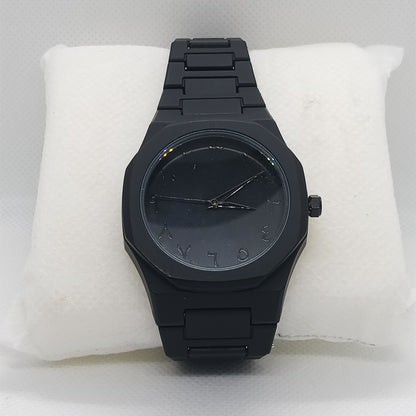 Black watch on a white cushion with a light gray background