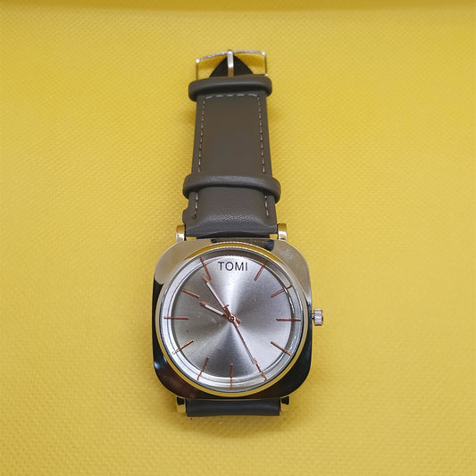 Wristwatch with brown leather strap and silver case on a yellow background