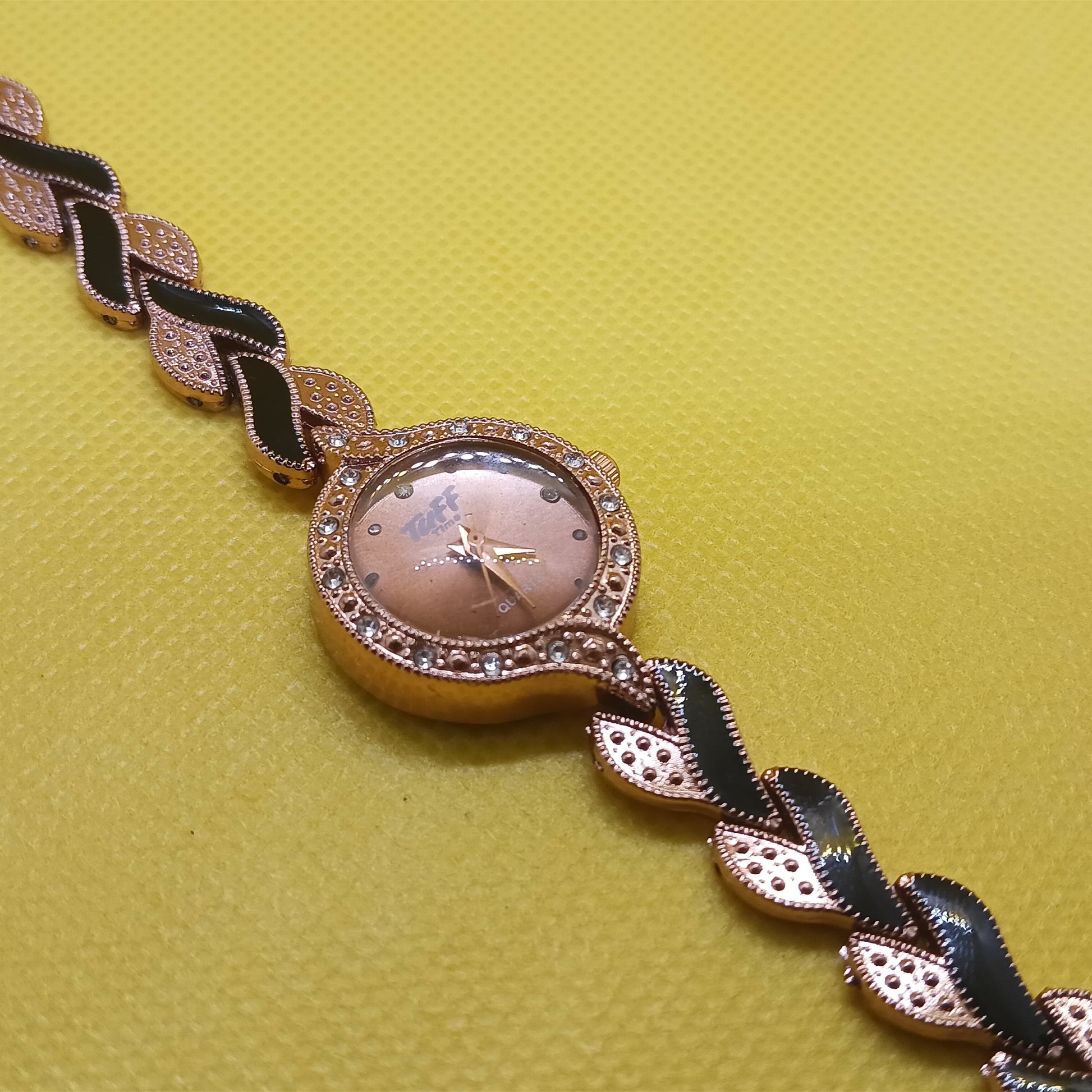 Wristwatch with decorative band on a yellow background