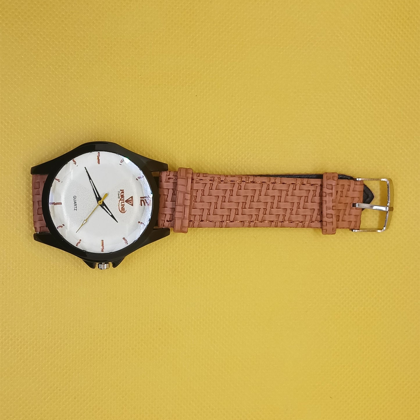 Watch with a brown woven strap on a yellow background