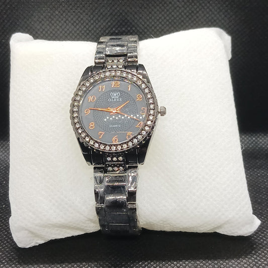 Black watch with a detailed face on a white cushion against a dark background