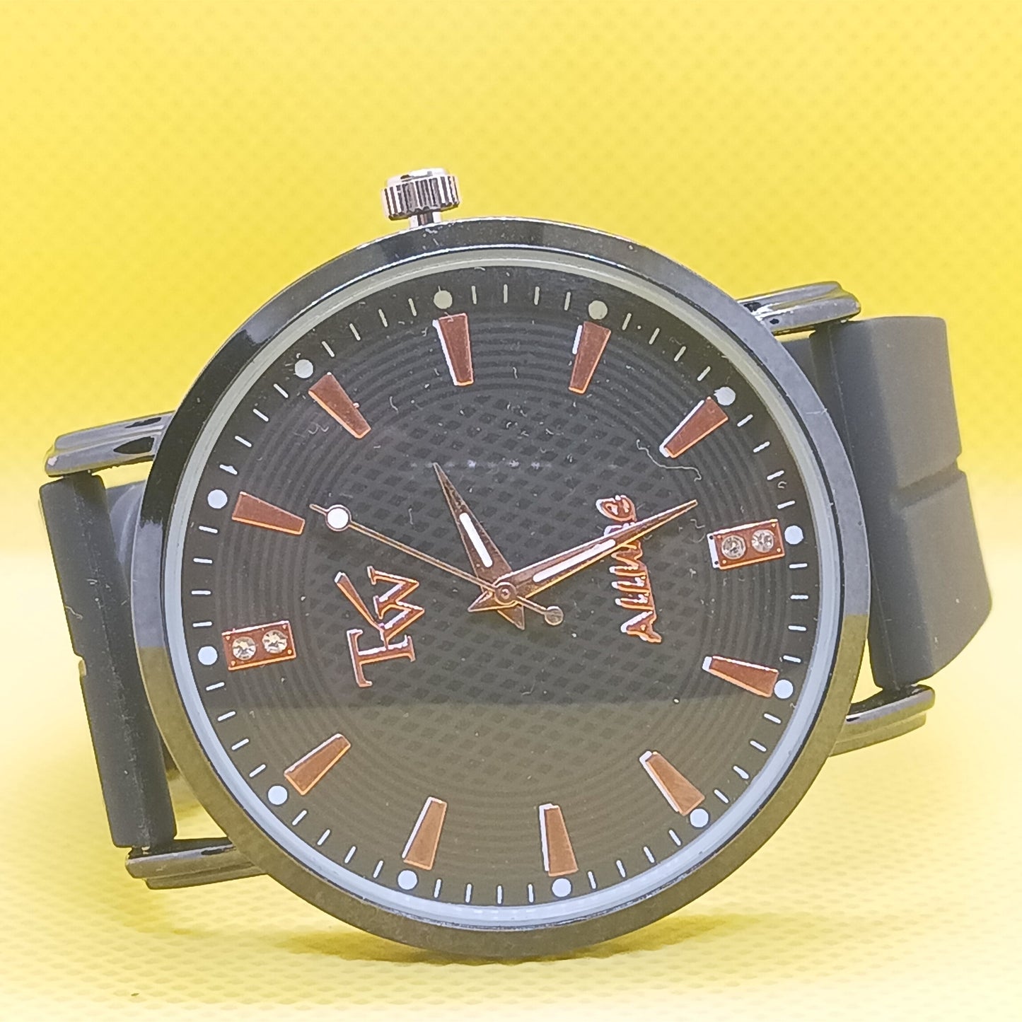 Wristwatch with black strap and brown dial on a yellow background