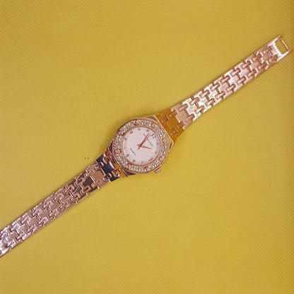 Gold watch with diamond-studded face on a yellow background