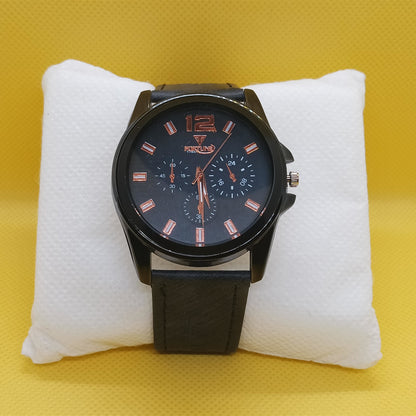 Black wristwatch with a detailed face on a white cushion against a yellow background