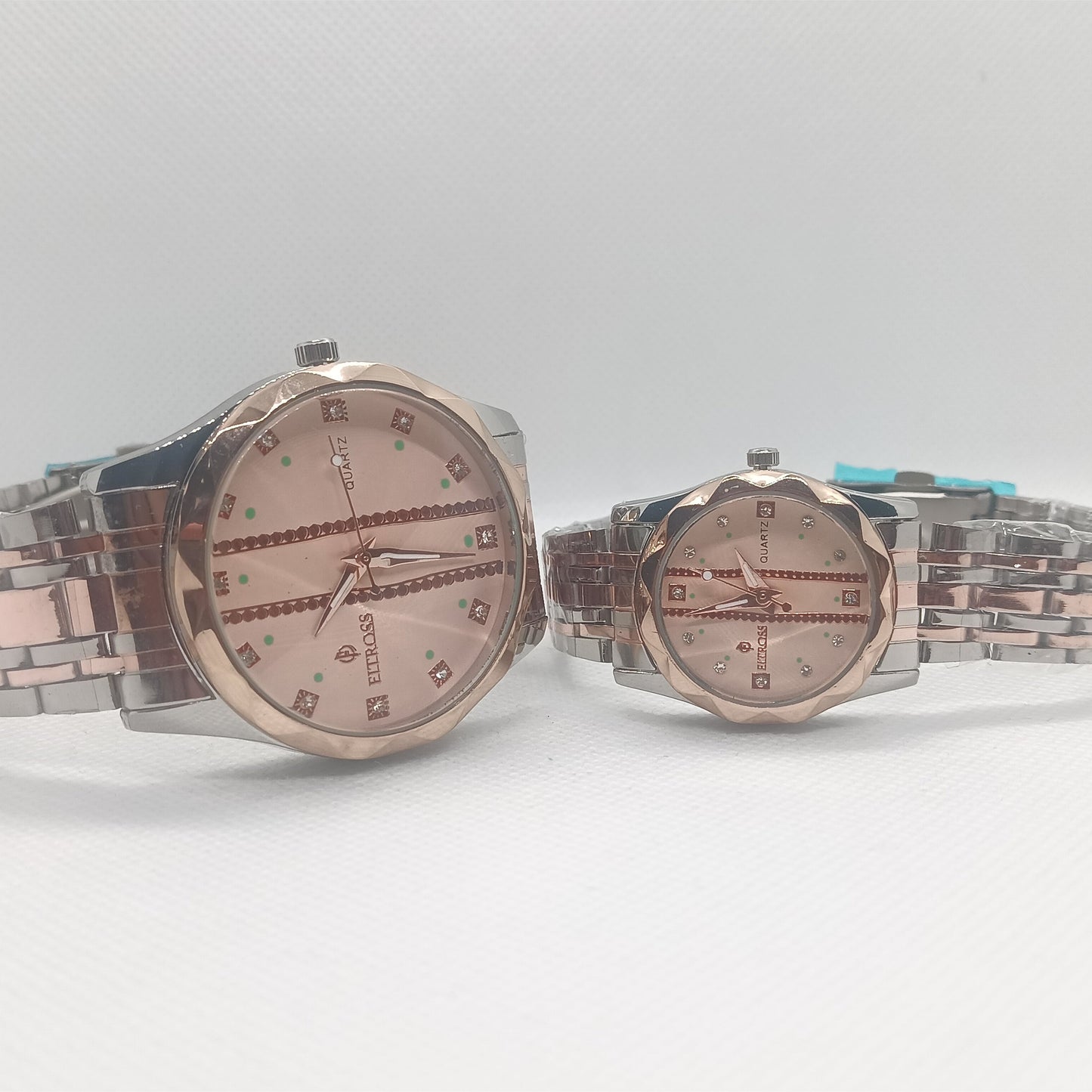 Two watches with metallic bands on a light gray background