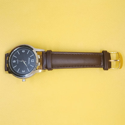 Watch with brown leather strap on a yellow background