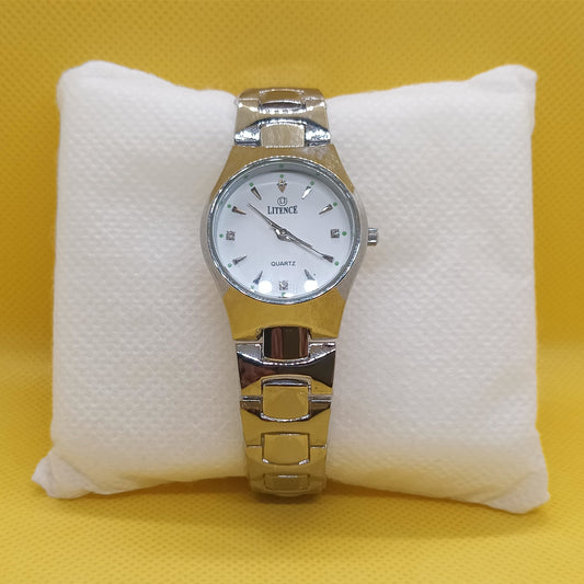 Silver watch on a white cushion against a yellow background
