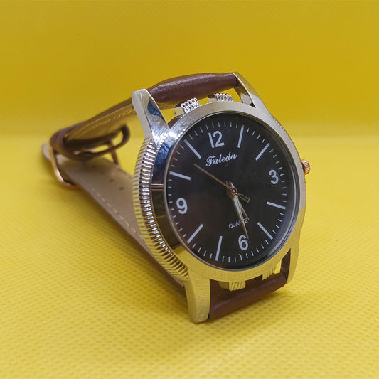 Wristwatch with brown strap and black dial on a yellow background