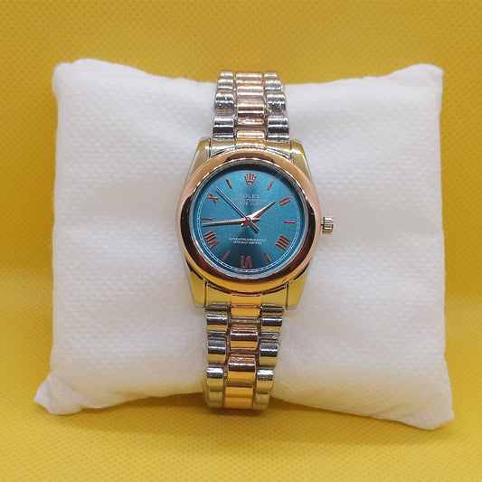 Gold and silver watch with a blue face on a white cushion against a yellow background