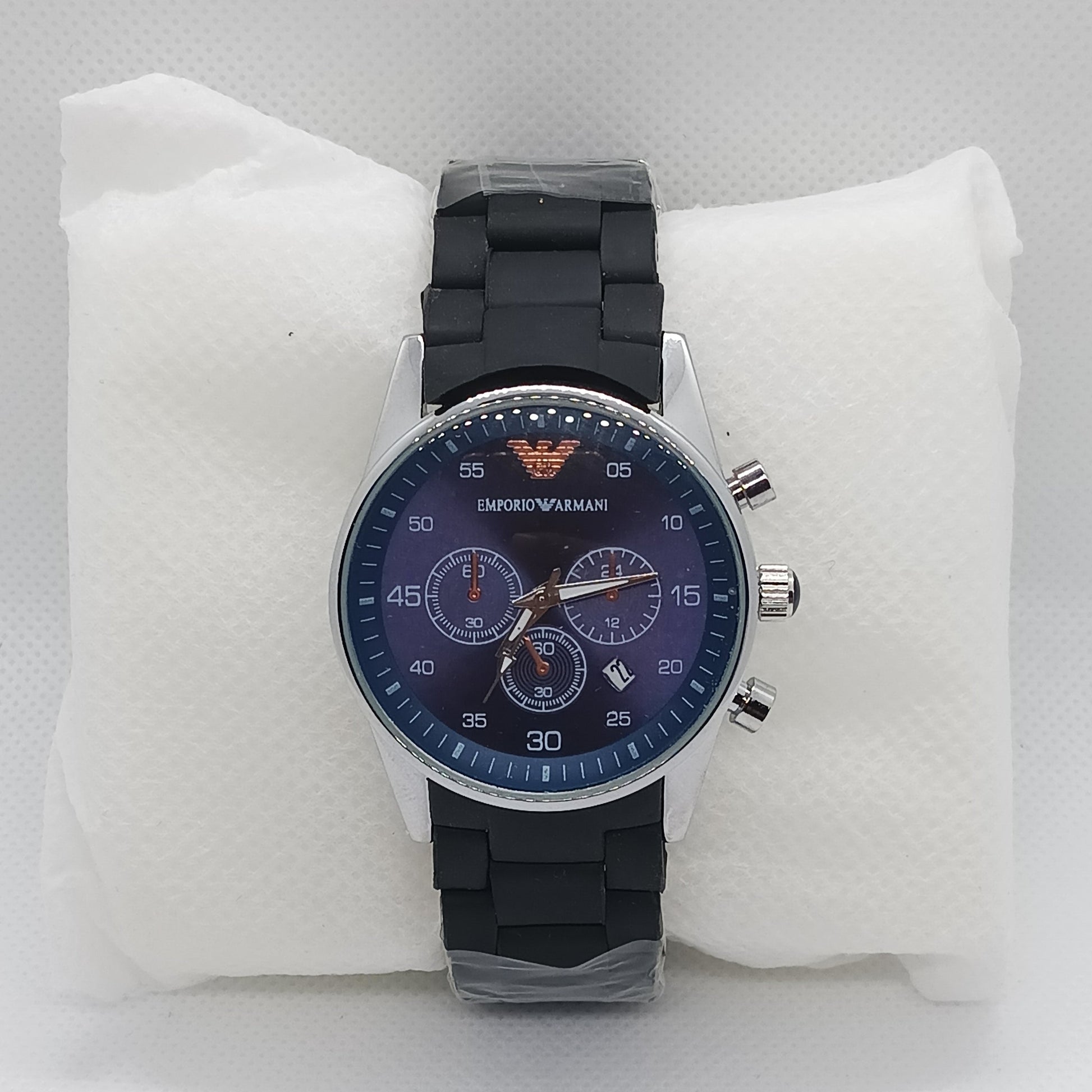 Wristwatch with black strap and blue dial on a white cushion