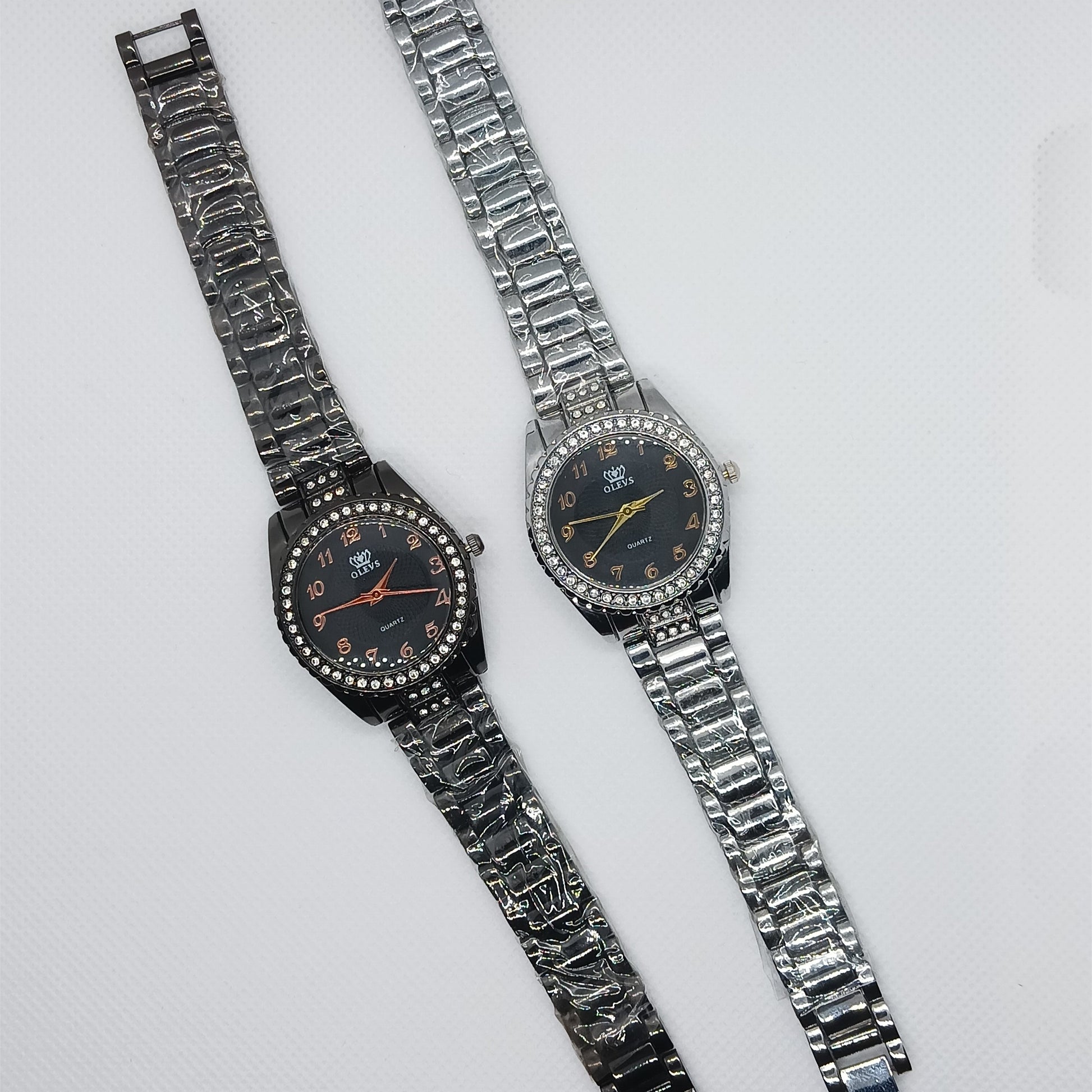 Two silver wristwatches with decorative bands on a light gray background