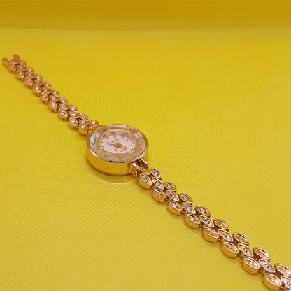 Gold wristwatch with diamond-studded chain on a yellow background