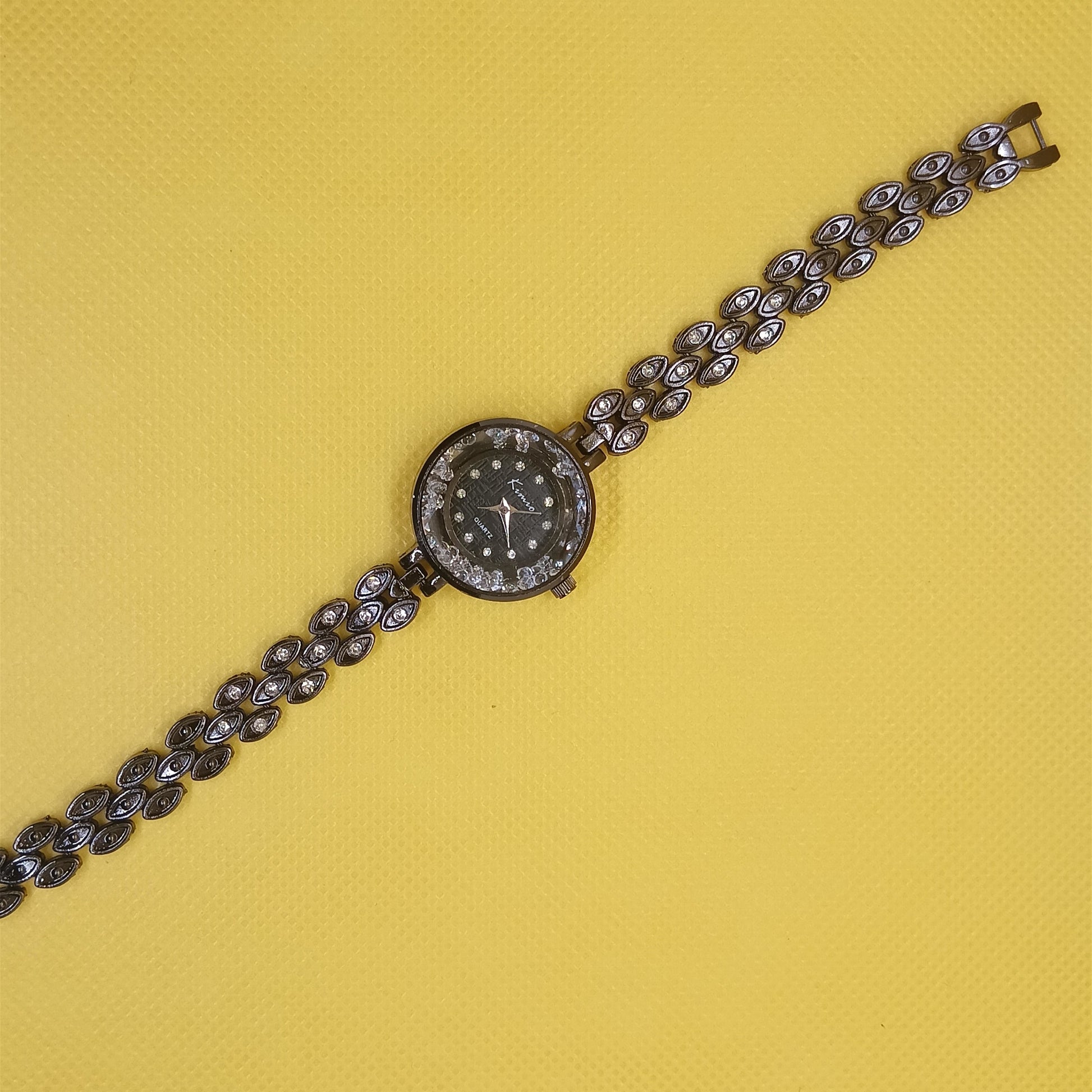 Wristwatch with decorative chain on a yellow background